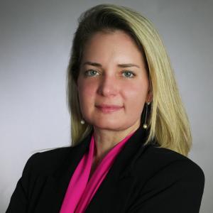 Carolina Vester, arms crossed in professional pink shirt and black blazer