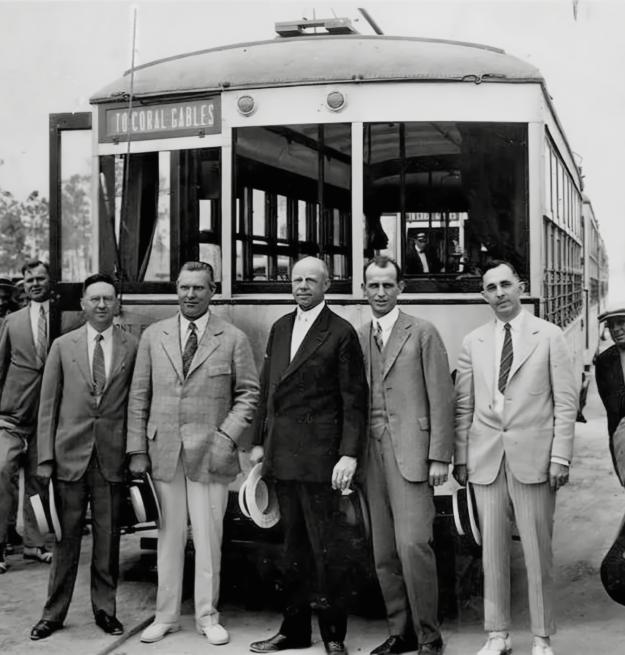 Black and white photo of George Merrick Doc Dammers, Jack baldwin, and Telfair Knight in front of a trolley 1925