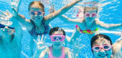 kids waving hello under the pool